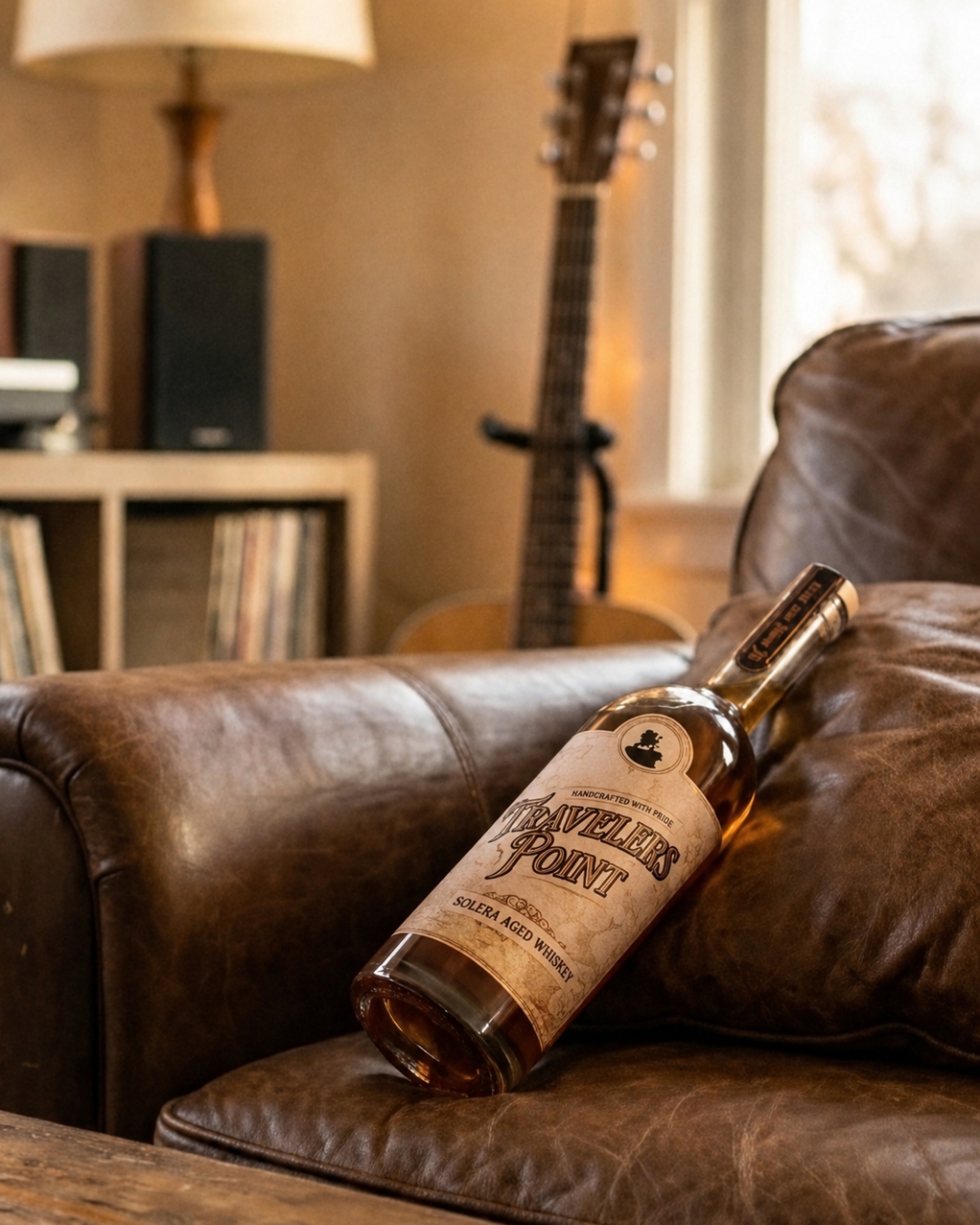 Travelers Point whiskey bottle resting on a leather sofa in a warm living room
